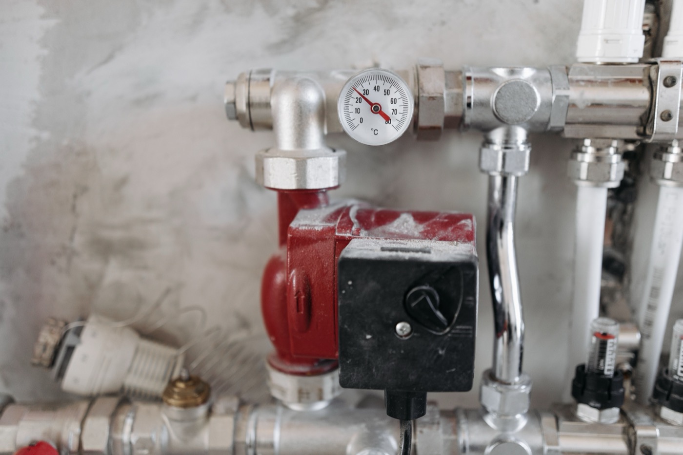 Close-up of a heating system valve and temperature gauge on a hot water tank in Abbotsford, BC